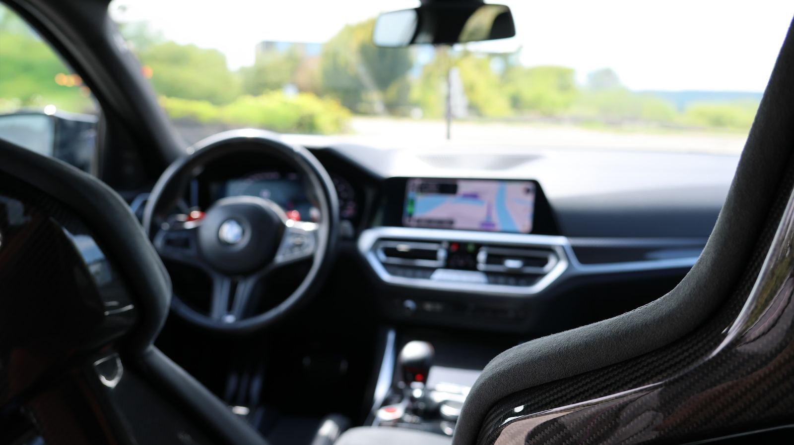 Zicht vanuit de BMW M3 Competition van RevMax: M stuur, dashboard en carbon kuipstoel